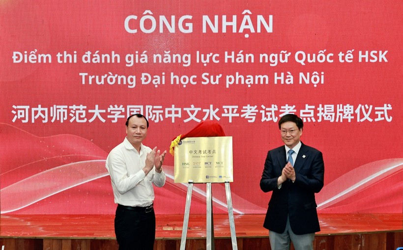 PGS.TS Nguyễn Đức Sơn - Phó Hiệu trưởng Trường ĐH Sư phạm Hà Nội (bên trái) nhận quyết định phê duyệt liên kết tổ chức thi chứng chỉ HSK từ ông Hồ Chí Bình trao quyết định.